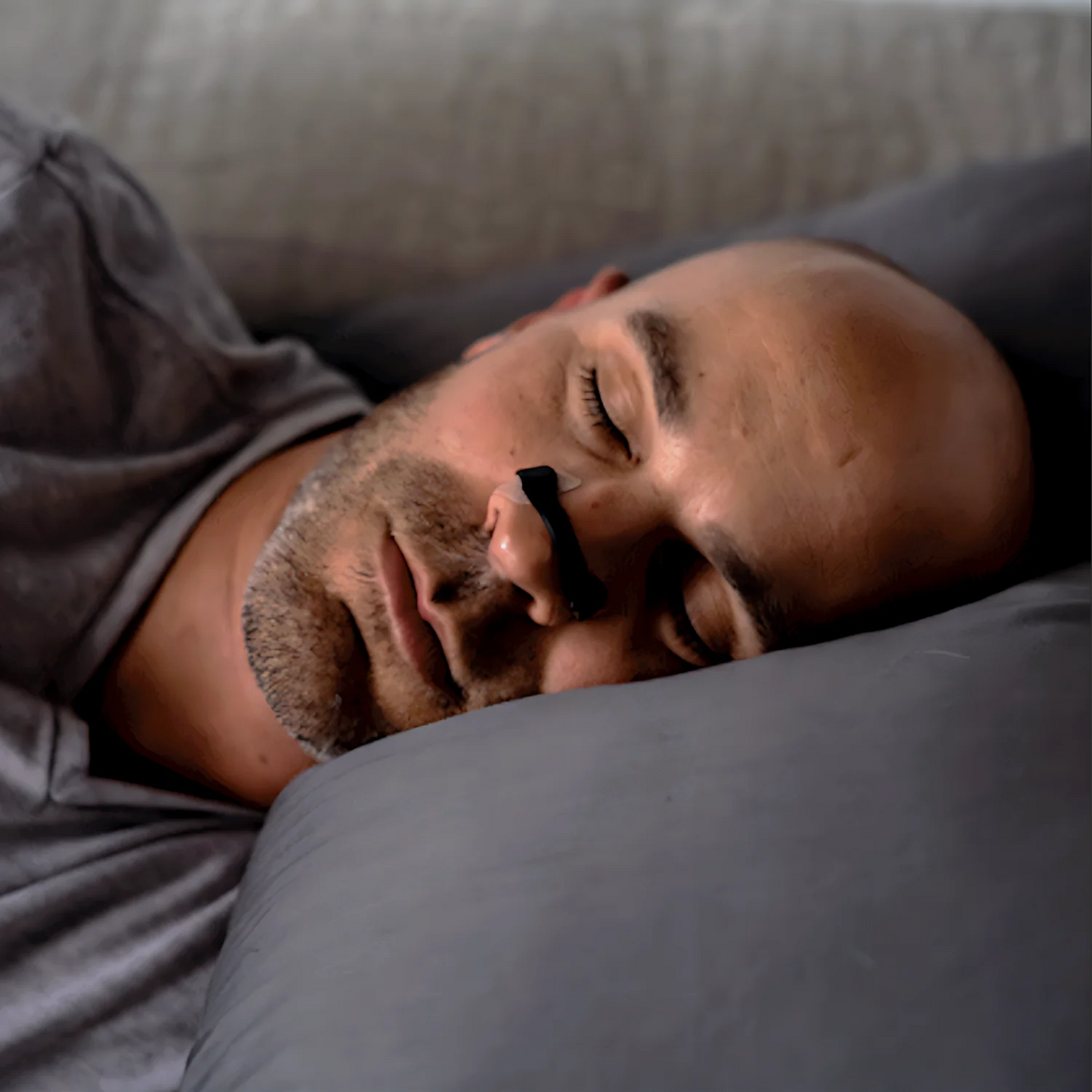 Man peacefully sleeping with Magnose™ nasal strip for better breathing and snoring relief.