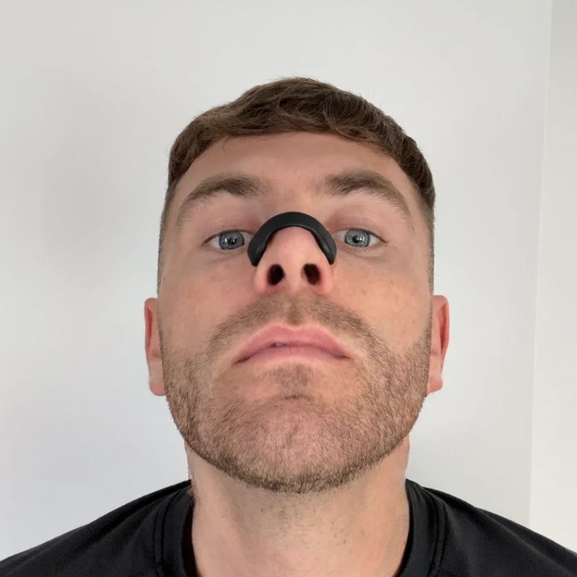 Man using Magnose™ magnetic nasal strip for improved breathing and sleep quality.